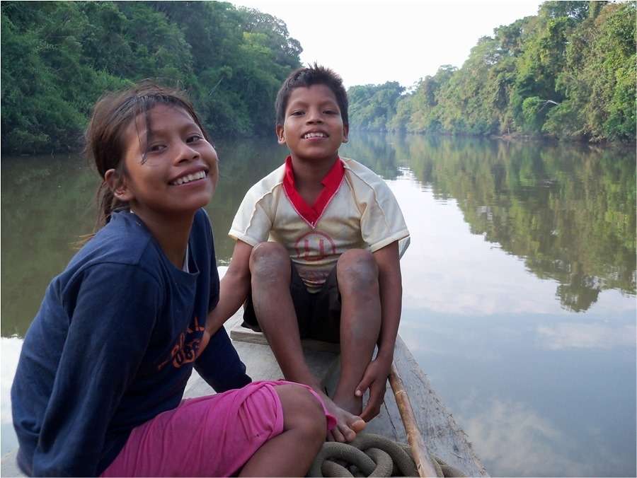 Photograph of two children in a boat on the river.